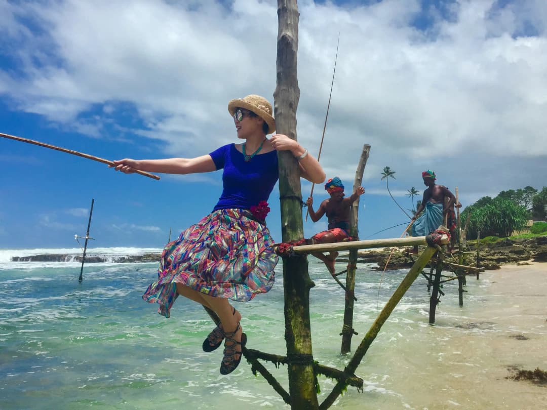 Tourist experience stilt fishing by Chamara Vijendra