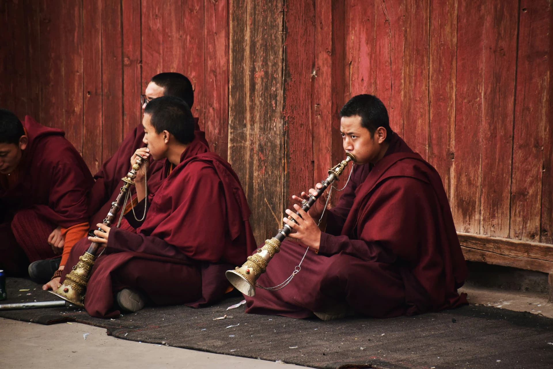 Buddhist monks playing a tibetan flute inside Sakya monastery, Tibet