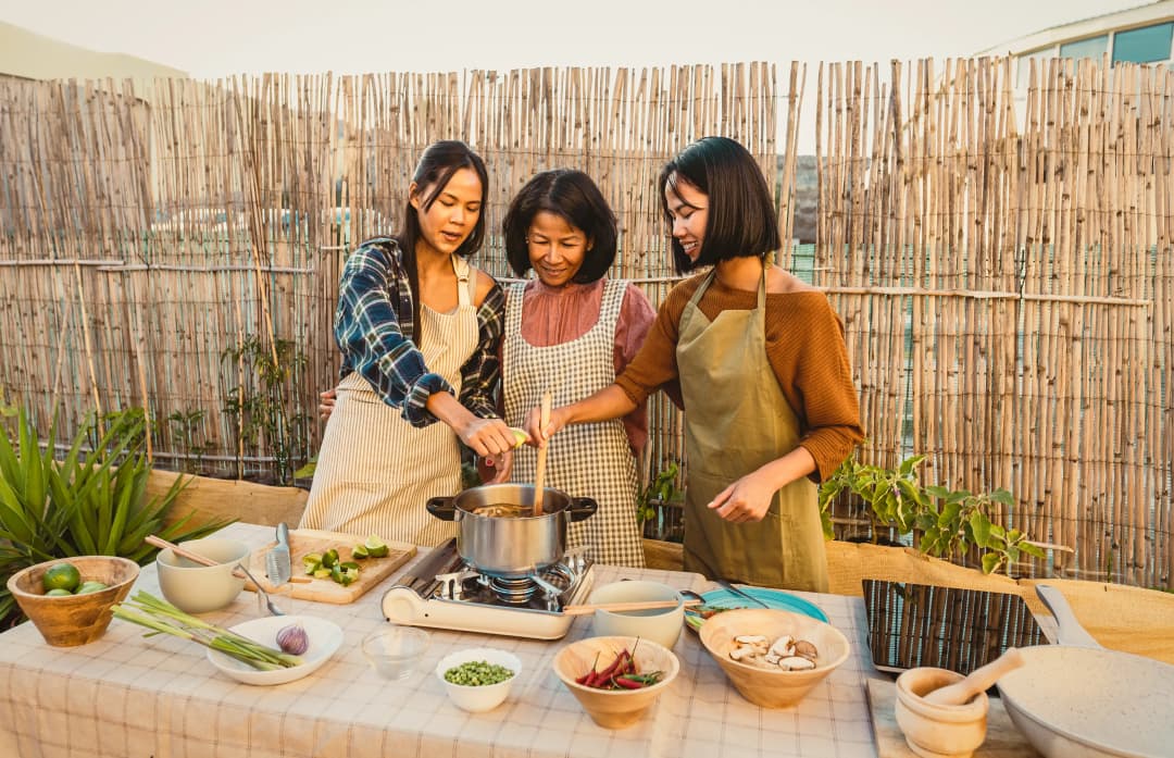 Happy Thai family having fun preparing soup recipe together