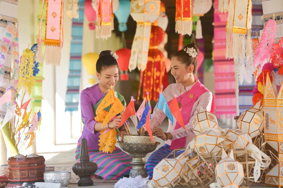 Two women in their traditional thai outfit sitting on floor